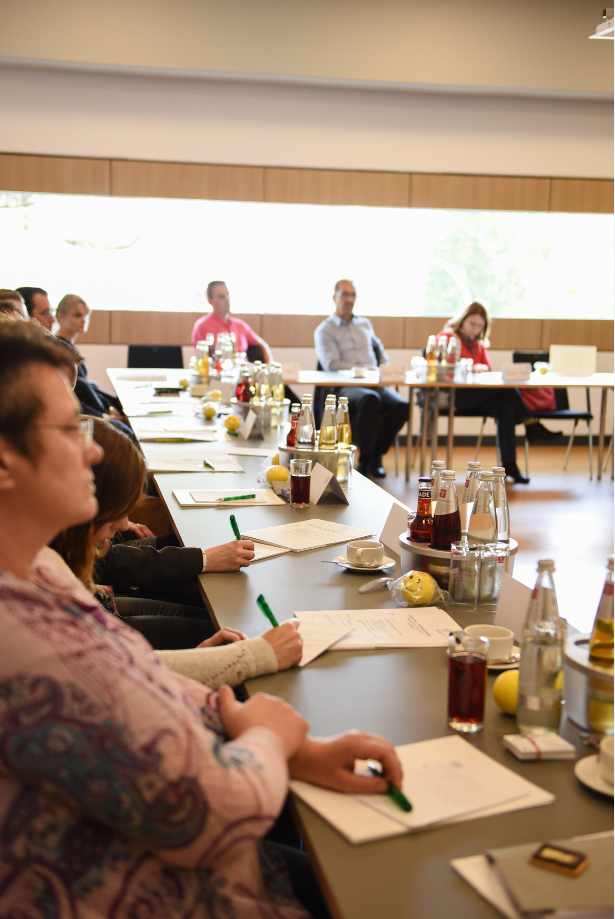 Menschen sitzen an Tischen bei Veranstaltung