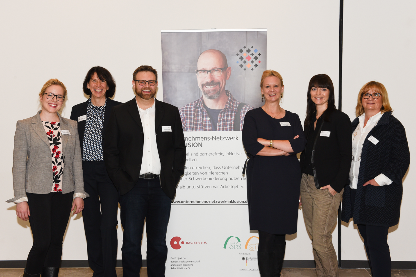 Gruppenfoto - sechs Personen vor Roll-up