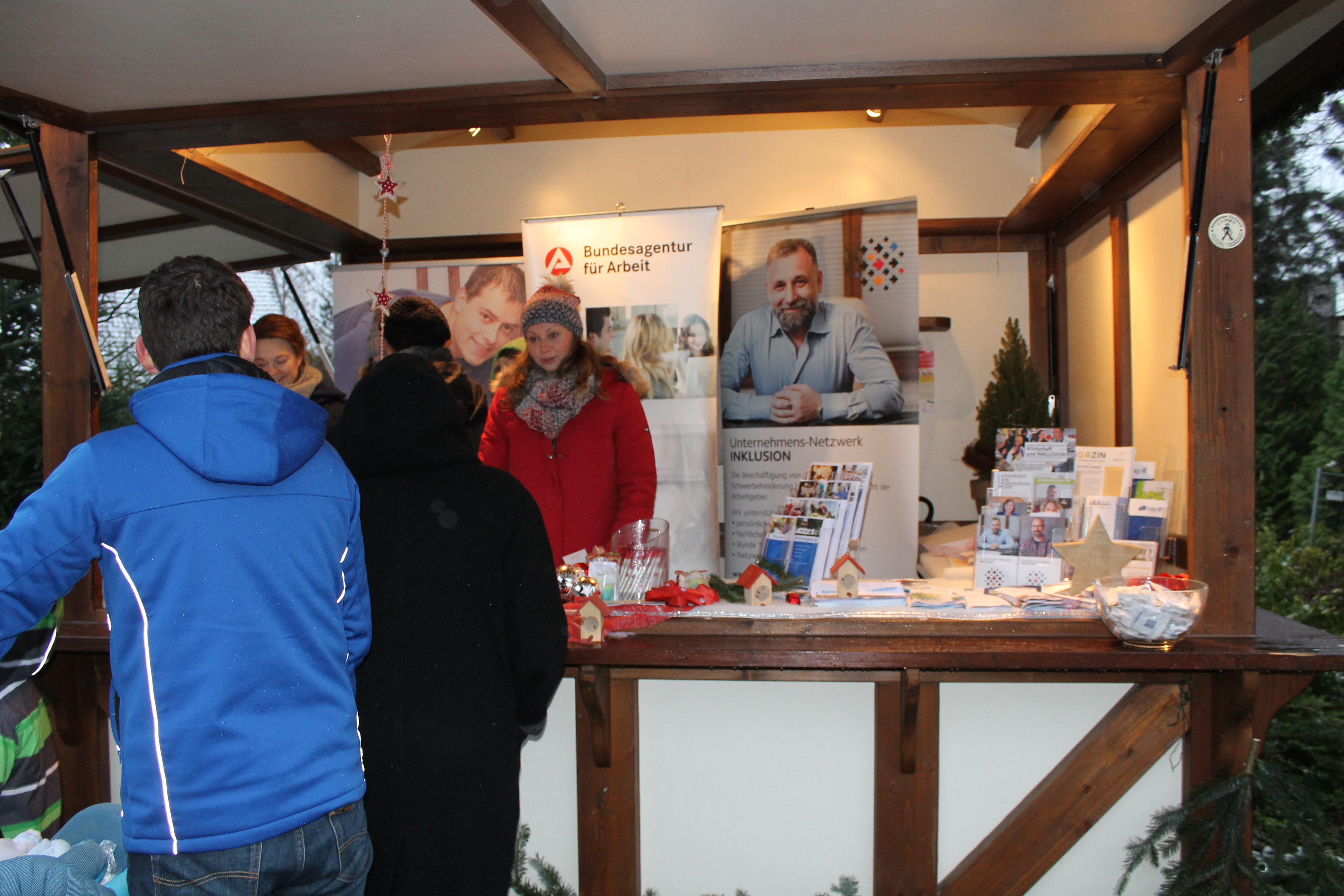 Beratungsgespräch an einem Weihnachtsmarktstand