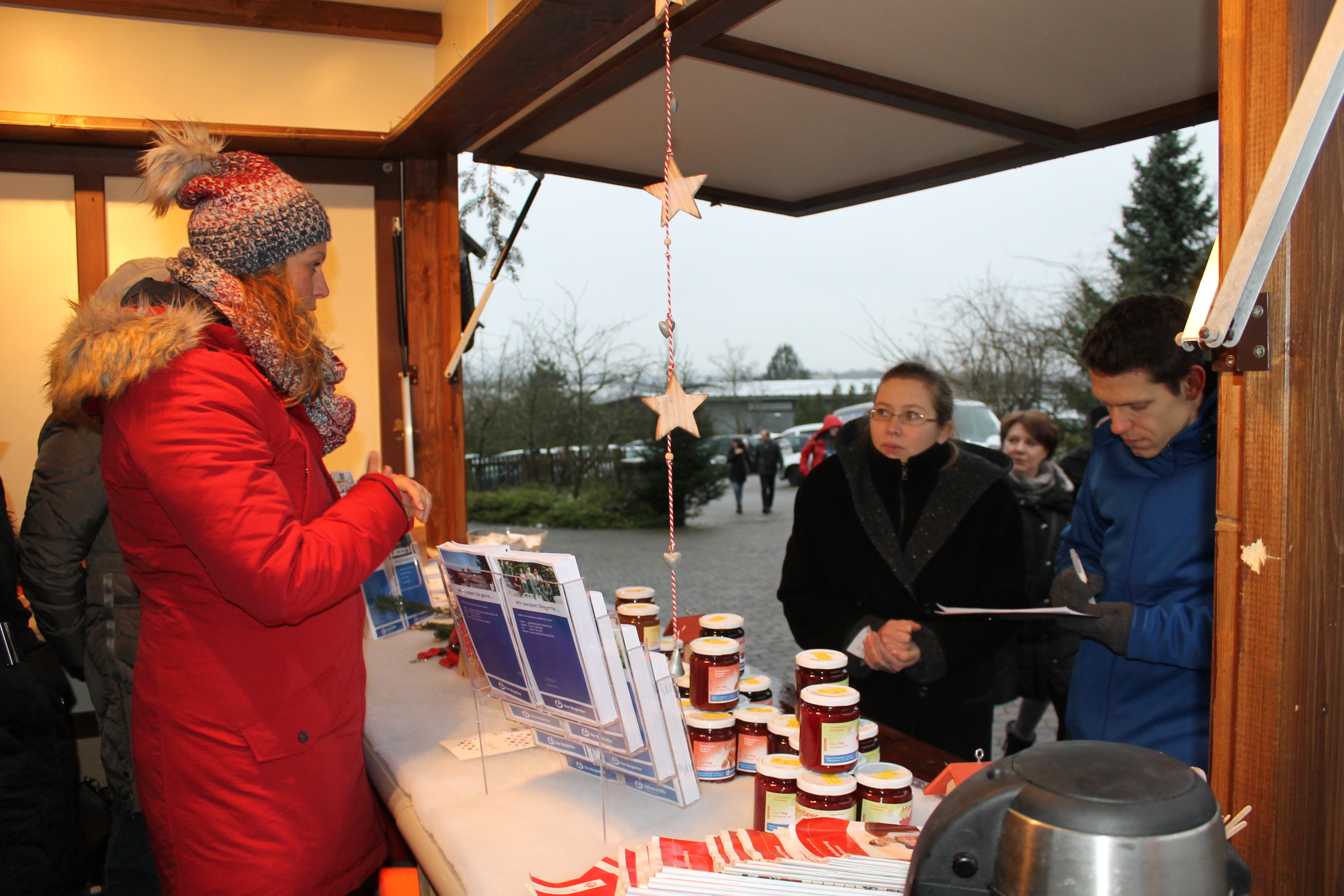 Beratungsgespräch an einem Weihnachtsmarktstand