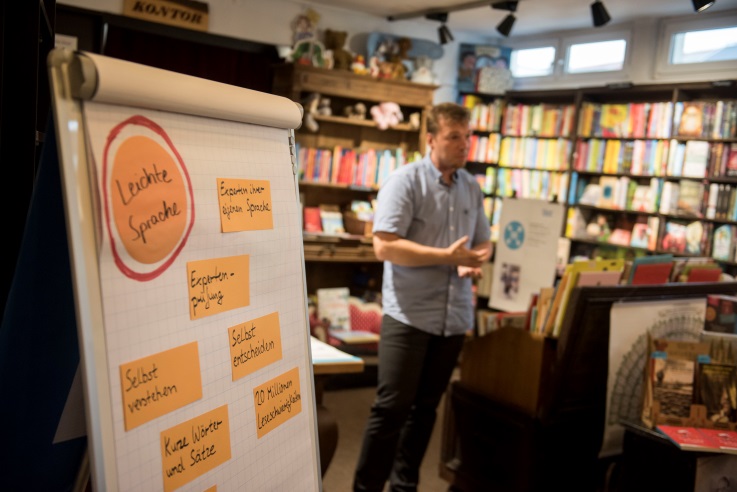 Flipchart steht in einer Buchhandlung und Mann erzählt