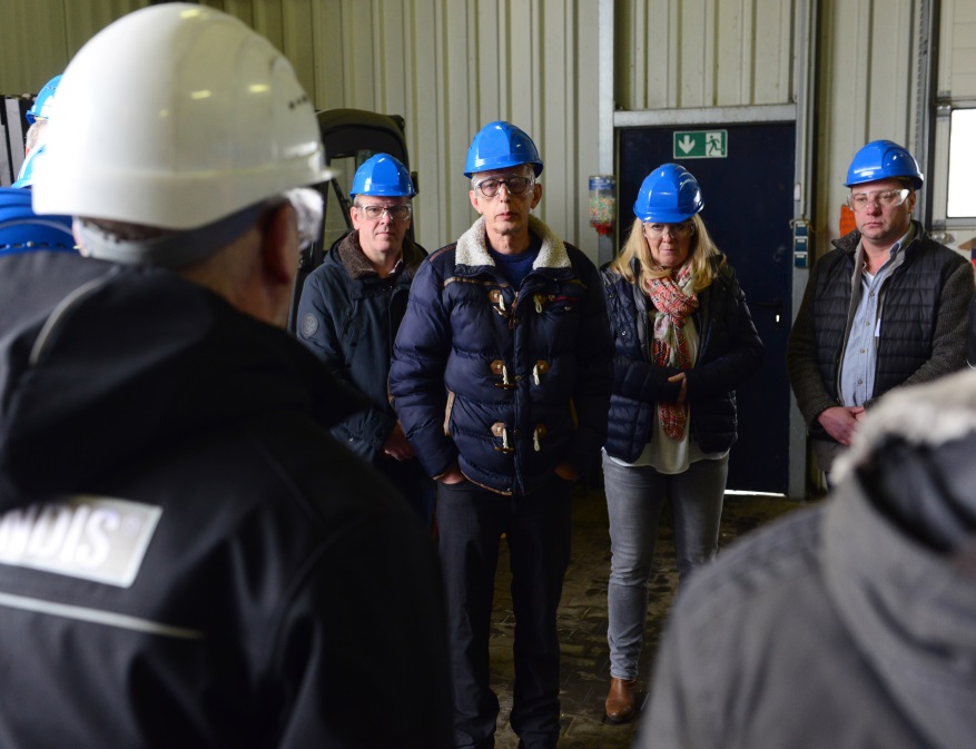 Männe rund Frauen mit blauen Helm auf dem Kopf in Werkshalle